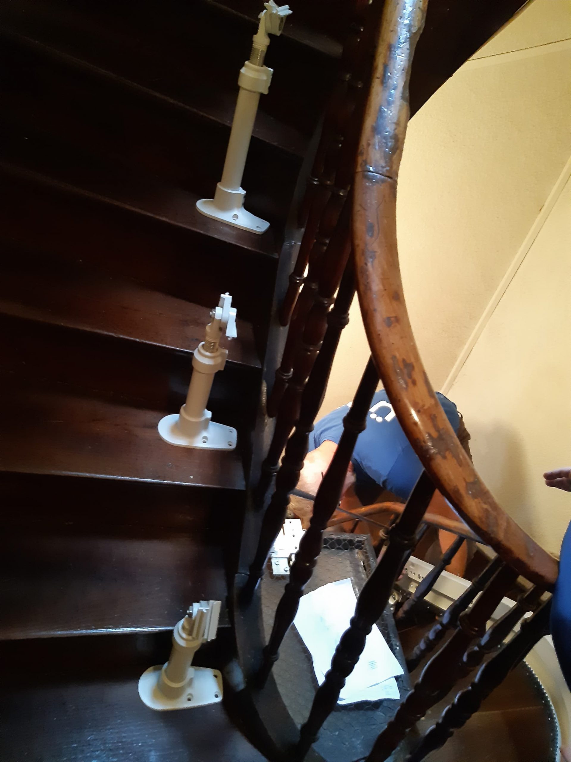 Pieds de fixation pour rail de monte-escaliers courbe installé sur un escalier